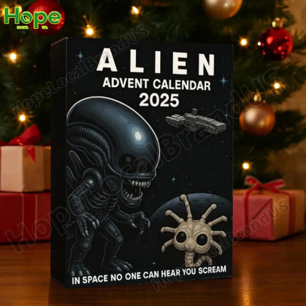 The Alien Advent Calendar 2025 box is set up as a holiday decoration next to a Christmas tree and wrapped presents!
