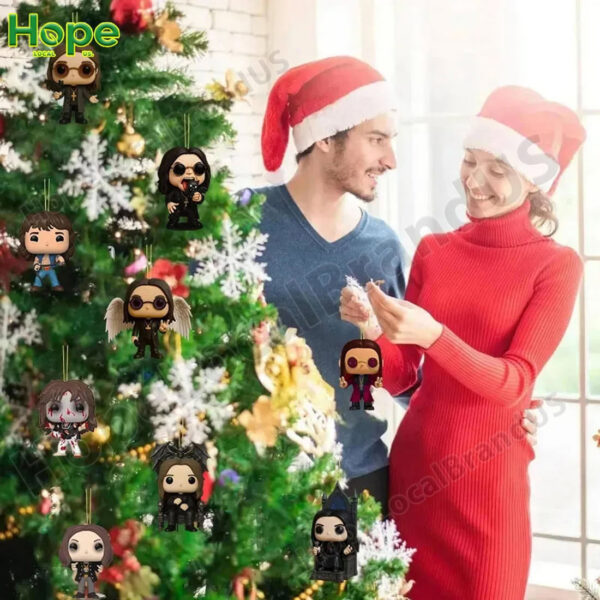 A smiling man and woman wearing Santa hats are decorating a Christmas tree with Ozzy Osbourne ornaments!