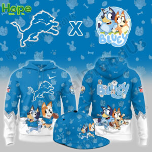 A blue hoodie featuring Bluey and Bingo from the children's show "Bluey" alongside the Detroit Lions logo. The hoodie has a playful design with characters in sports outfits, engaging in activities like football, with paw prints and other cute symbols in the background.