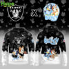 A hoodie featuring the Las Vegas Raiders logo on the front and Bluey and Bingo running with a football on the back, in black with white accents.